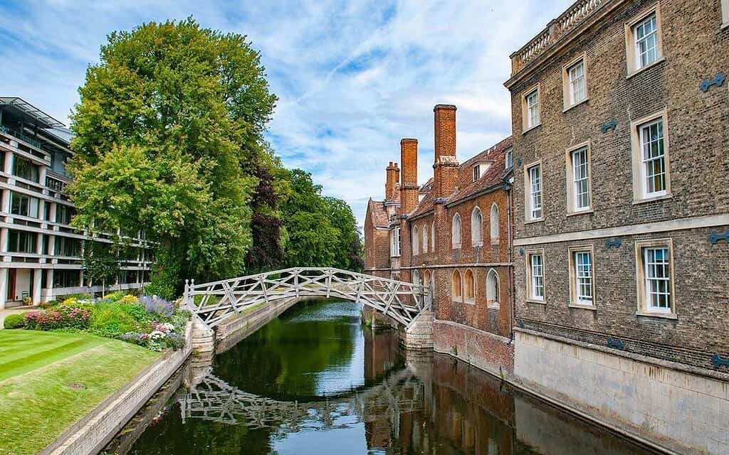Picturesque Cambridge canal with historic architecture and lush greenery, perfect for guided tours.