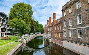 Picturesque Cambridge canal with historic architecture and lush greenery, perfect for guided tours.
