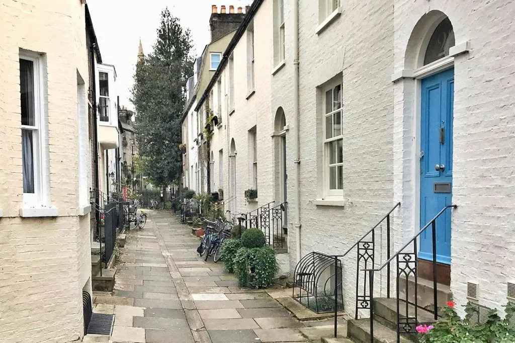 Charming Cambridge street with colourful homes, bicycles, and historic architecture. Perfect for guided Cambridge photo tours.