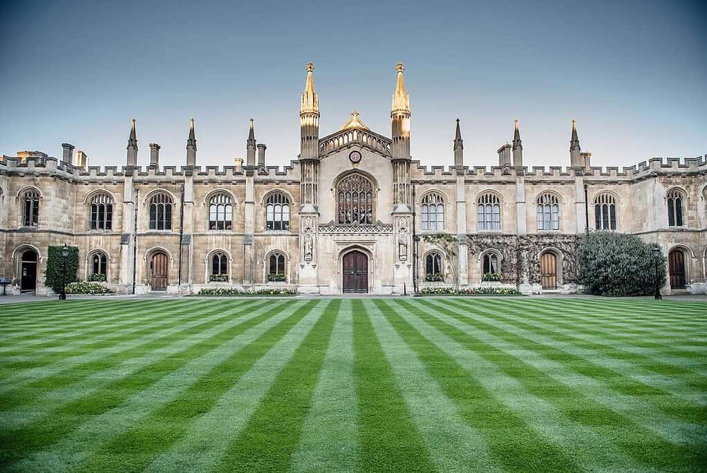 Gothic college in Cambridge with ornate architecture, large windows, and well-maintained lawn, perfect for guided tours.